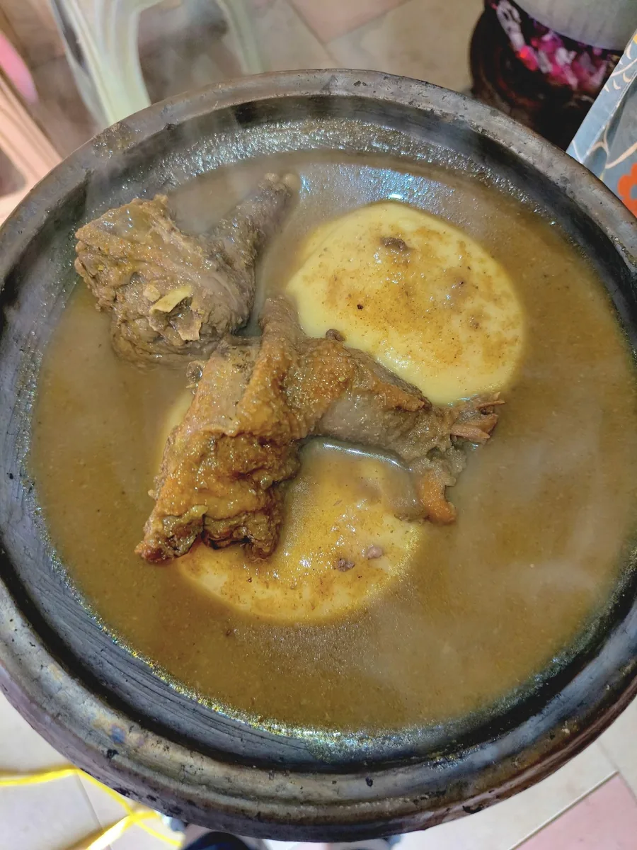 Hot soup and fufu served in a black bowl